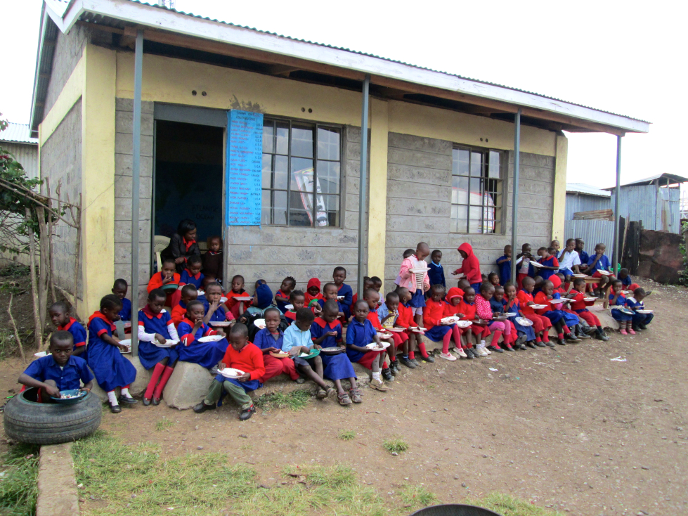 Children sitting outside the classroom for lunch