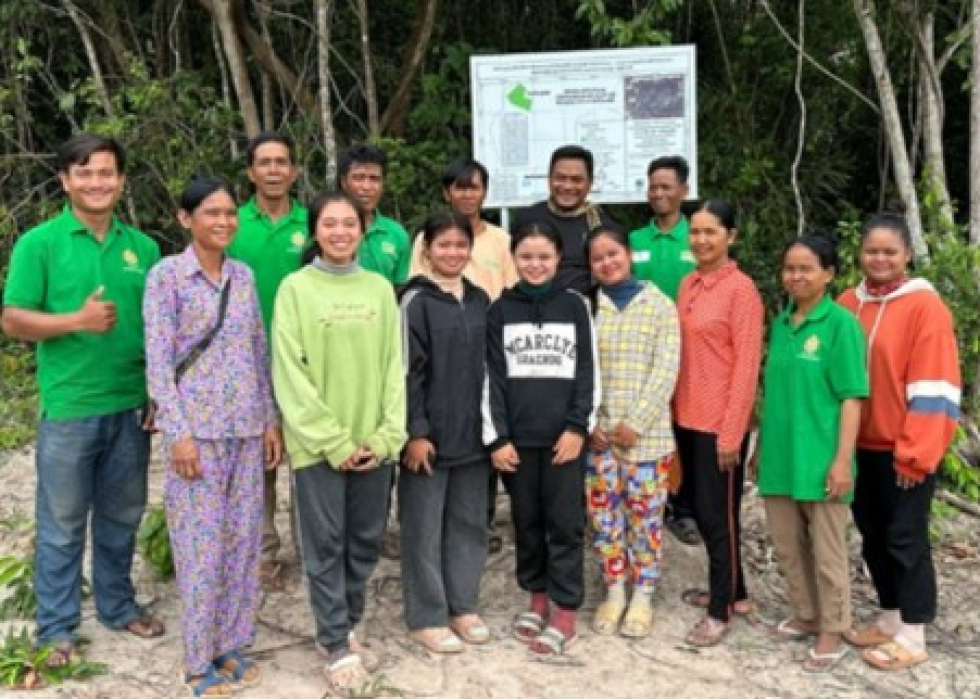 Youth installing a billboard at the forest entrance